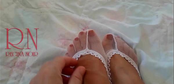  White socks. Cute chick lies on the bed, smiles, gracefully bends.